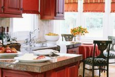a bold red vintage kitchen with pretty cabinets, stone countertops and dark chairs and stools looks very refined and cool