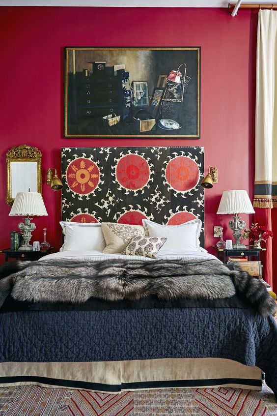 a bright and catchy bedroom with a bold red accent wall, a bed with a unique patterned headboard, refined nightstands and lamps