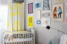 a colorful nursery with white furniture, bright textiles, a gallery wall with colorful artworks and a cage chandelier