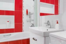 a contemporary red and white bathroom with large scale tiles, white niches, a large mirror and a white vanity with drawers