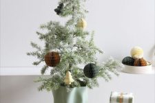 a cool tabletop Christmas tree with paper ornaments and in a mint-colored planter is a lovely idea