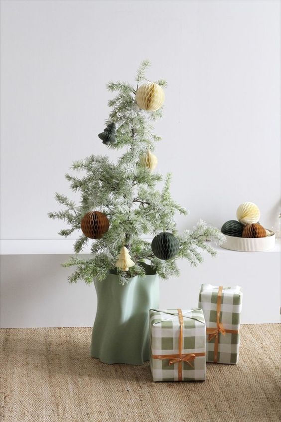 a cool tabletop Christmas tree with paper ornaments and in a mint-colored planter is a lovely idea