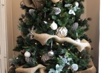 a country Christmas tree with pinecones, pale greenery, snowflakes, metallic ornaments and yarn balls is chic
