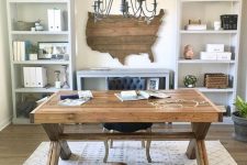 a cozy neutral rustic home office with a wooden trestle desk, a state artwork, a metal chandelier and dove grey storage units