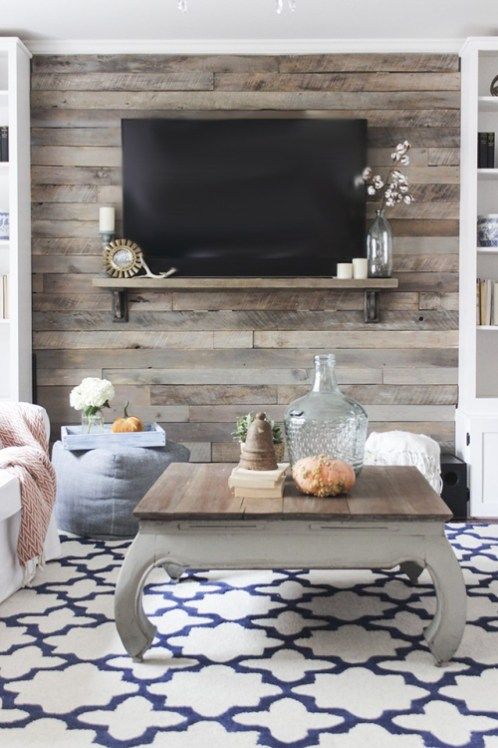 a cozy space with a rustic reclaimed wooden wall and a coffee table that matches, wood adds a rustic feel here