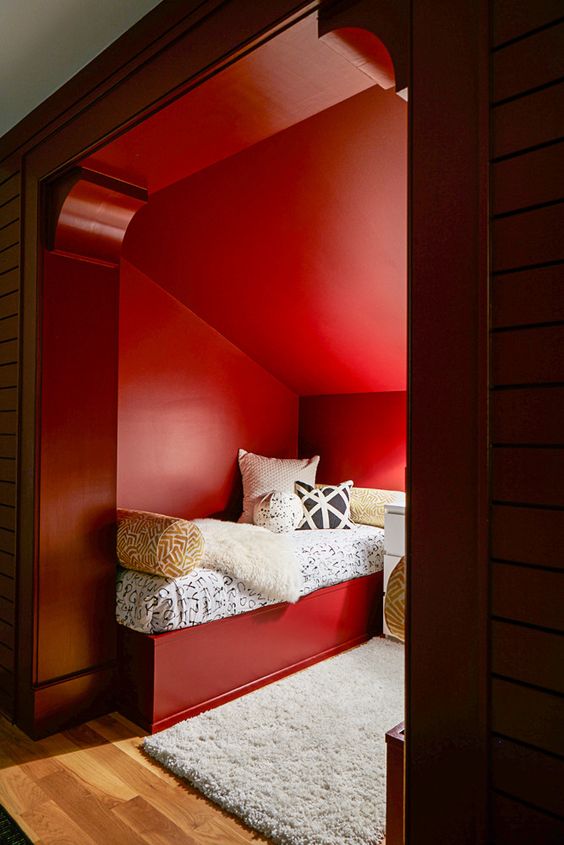 a double guest bedroom with red walls, red beds and printed bedding looks cool and very cozy