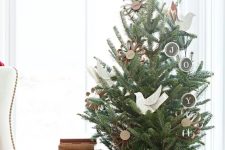 a farmhouse tabletop Christmas tree with paper birds, paper ornaments placed in a copper bathtub