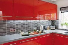 a fiery red contemporary kitchen with a concrete countertop and a pretty grey tile backsplash is a bold and cool solution