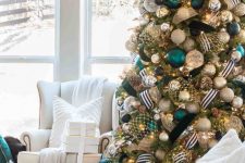 a modern glam Christmas tree with lights, gold glitter, emerald, black and silver ornaments, black and striped ribbons