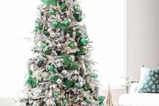 a refined modern Christmas tree with emerald ribbons, emerald and dark green ornaments, beads and metallic touches