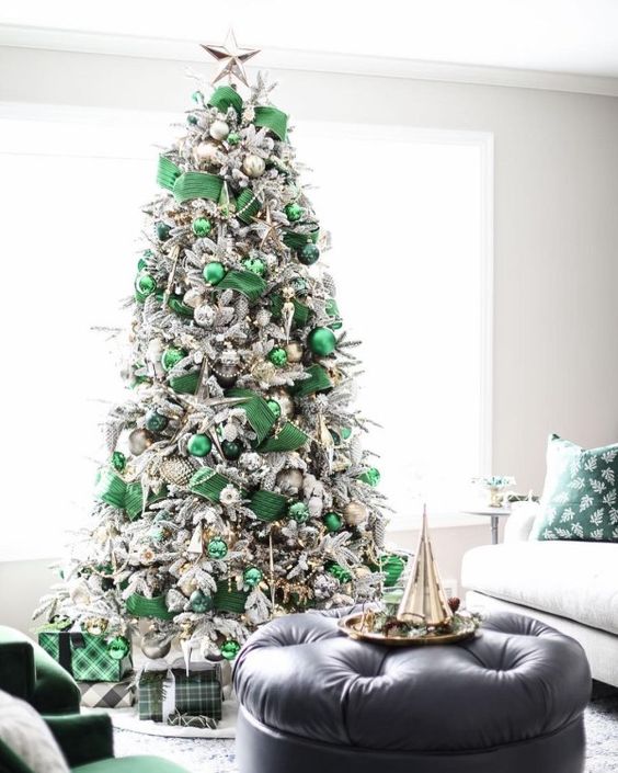 a refined modern Christmas tree with emerald ribbons, emerald and dark green ornaments, beads and metallic touches
