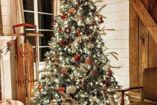 a rustic Christmas tree with lights, red and silver ornaments, pinecones, beads and plaid balls is lovely and cool
