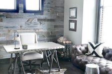 a rustic home office with a trestle desk, a white chair, a leather sofa, a metal stool, a metal chandelier and a faux fur rug