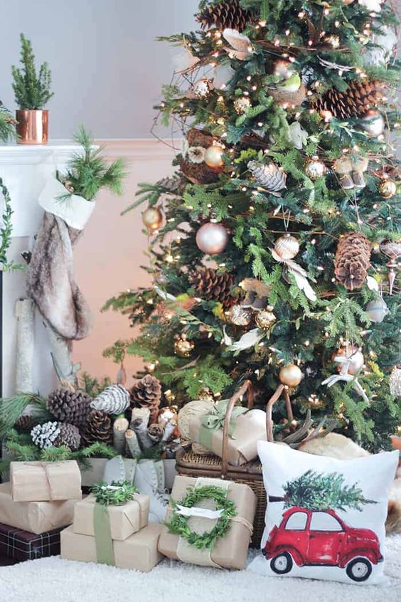 a rustic lux Christmas tree with lights, metallic ornaments, pinecones, leaves, twigs and baskets with pinecones next to the tree