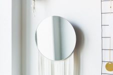 a simple round IKEA mirror hack with long white fringe to make it look more boho-like