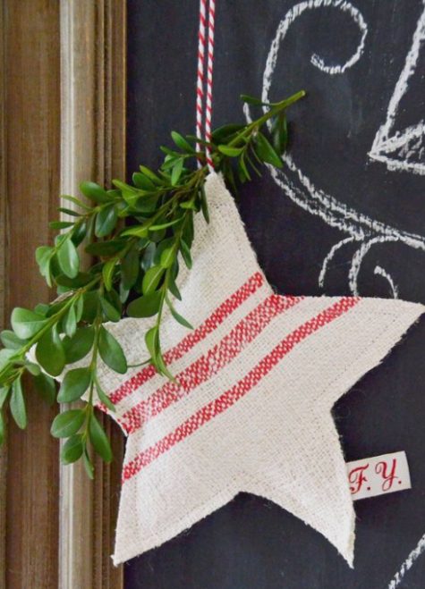 a striped red and white Christmas star ornament with evergreens and red and white twine is an easy DIY to make