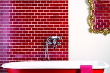 a stunning bathroom accented with a red subway tile wall and a red bathtub, a refined mirror is a bold and refined space