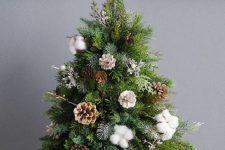 a stylish Christmas tree with pinecones, cotton and in a tree stump is a perfect woodland decoration