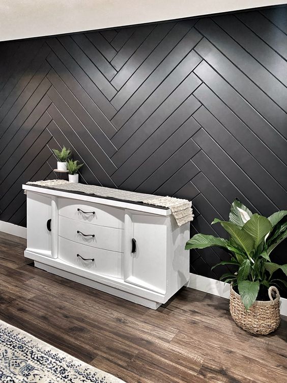 a stylish wooden accent wall clad ina herringbone pattern and painted black will make a cool statement in your entryway
