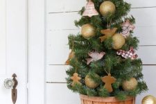 a tabletop Christmas tree decorated with gold ornaments, gingerbread men, a star topper is a cool solution