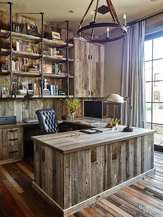a vintage meets rustic home office with a wall and furniture fully made of reclaimed wood, a reclaimed wood floor, a metal chandelier and a leather chair