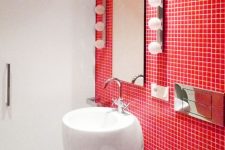 an ultra-modern red modern done in white and accented with a red tile wall, lights, white appliances and sleek surfaces