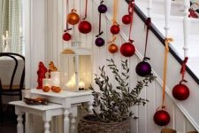 06 Christmas stairs decor with bold oversized ornaments on ribbons is fun, bright and very cool