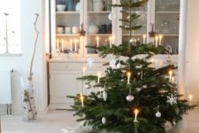 07 a Nordic Christmas tree with lights, snowflakes and ornaments, with white faux fur covers under the tree is very cozy