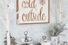 11 a bar idea for a winter wonderland space – a sign, some flocked Christmas branches, white trees, silver and white ornaments, candles and pompoms