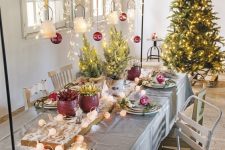 11 a bright Christmas table setting with red vases and ornaments, lanterns and red ornaments hanging over the table
