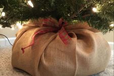 15 cover your Christmas tree with burlap and a add a plaid ribbon bow to make it look a bit rustic and very cozy
