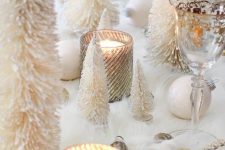16 a lovely winter wonderland tablescape with faux fur, white and gold ornaments, candles in glass candleholders, mini tinsel Christmas tres