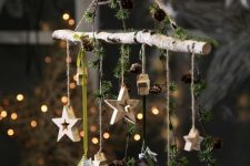 17 a natural Christmas decoration of a stick, greenery, pinecones, ornaments and wooden stars is lovely