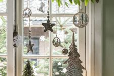 24 window Christmas decor with fresh greenery, silver and white ornaments, pretty wooden ornaments and mini trees
