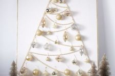 30 a refined wall-mounted Christmas tree of beads, gold and silver ornaments and a silver vine star topper
