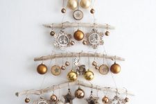 31 a wall-mounted Christmas tree of branches, gold and silver ornaments, wooden stars and snowflakes plus deer