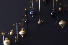 33 a wall-mounted Christmas tree of lights, with gold, black and navy ornaments is a chic and bold idea to rock anytime