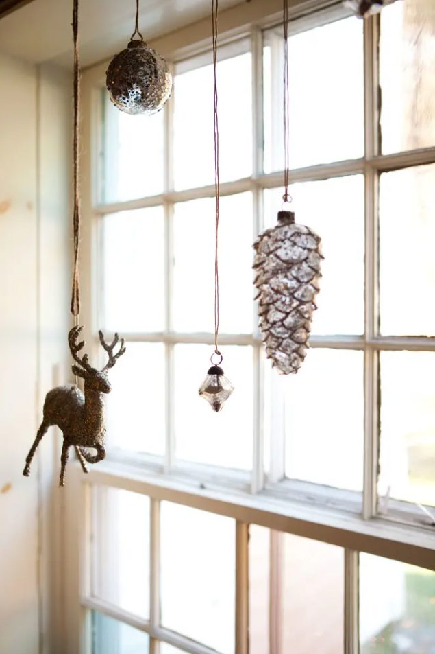 Christmas ornaments and figurines hanging on the window will make it look festive and super cool