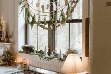 Christmas window decor with snowflakes, evergreens and wooden beads is cool and cozy