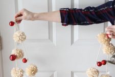 a Christmas garland of neutral pompoms and red ornaments is a truly holiday decoration to rock