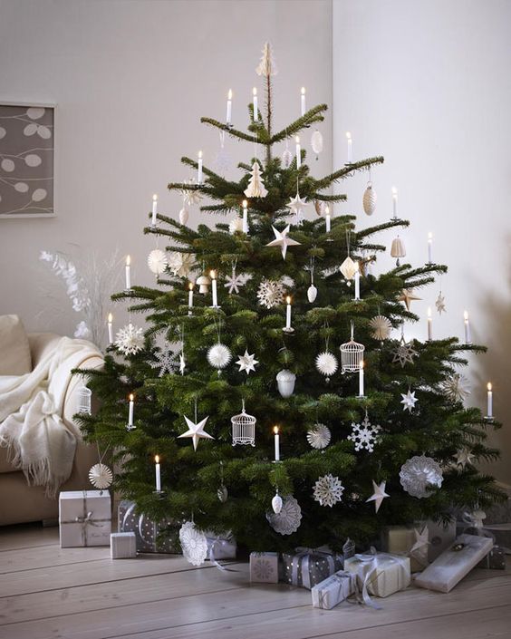 a Christmas tree decorated with candles and white ornaments and silver is a fabulous idea for a Nordic space