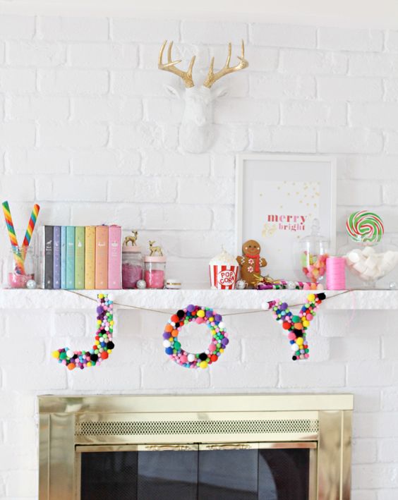 a banner with JOY letters made completely of colorful pompoms is a fun and cool idea to rock for Christmas