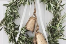 a beautiful greenery Christmas wreath with oversized vintage bells and a white ribbon bow on top is a lovely vintage decoration