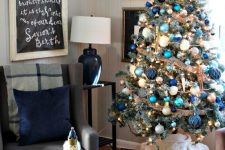 a bold Christmas tree with navy, green, blue and turquoise ornaments, burlap ribbons and a gold star topper