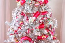 a bold and fun Christmas tree in silver, with hot pink and red ribbons, snowy pompom ribbons, colorful ornaments and ice cream ones