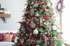 a bright Christmas tree decorated with plaid ribbons and ornaments, lights, snowflakes, deer and twigs is very cool