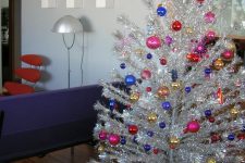 a bright and shiny Christmas tree with super colorful ornaments is a perfect idea for a mid-century modern space and it looks very catchy