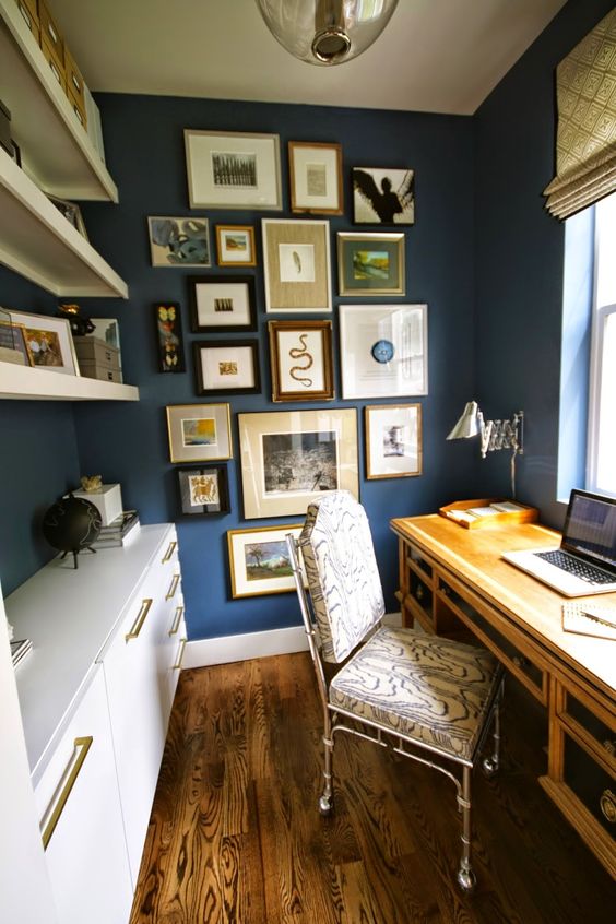 a bright and welcoming home office with blue walls, a vintage wooden desk, a white storage unit and open shelves and a gallery wall