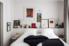 a catchy and contrasting bedroom with a ledge with artwork and books, a bed with contrasting bedding, nightstands and a black lamp