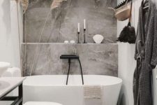 a modern bathroom with a stone tiles accent wall